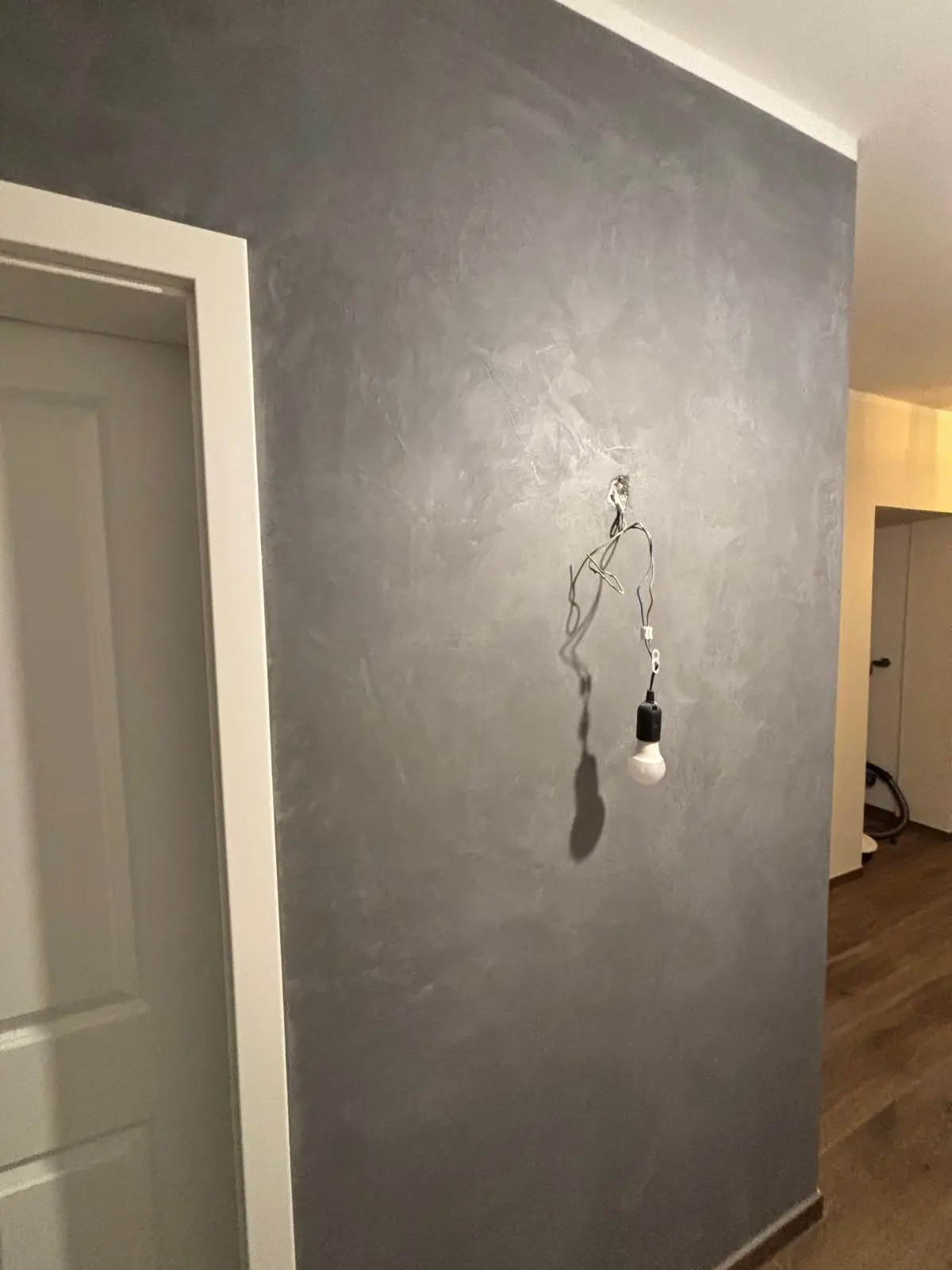 Gemalte Wand: Kreative Wandgestaltung mit fließenden, halbkreisförmigen Grautönen in moderner Wischtechnik
